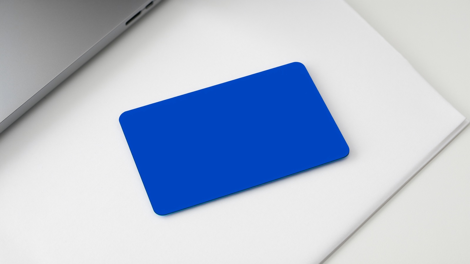 Payment card and receipt beside a laptop and stethoscope on a white desk