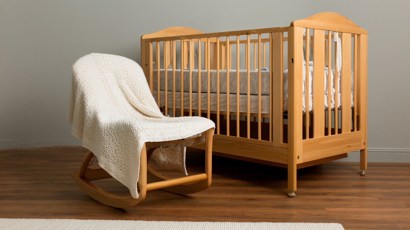Peaceful nursery with a wooden crib and knit blanket in soft morning light