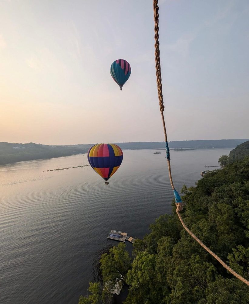 Two hot air balloons at sunrise over the calm St. Croix River, seen from Bethany's balloon